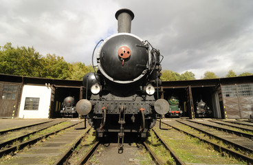 Obraz premium Old Vintage Steam Locomotive At The Train Depot 