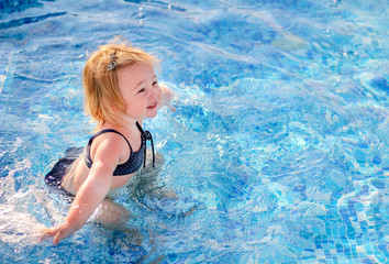 Fototapeta na wymiar Baby girl playing in pool