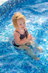 Fototapeta na wymiar Baby girl playing in pool
