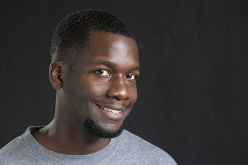 Portrait of a young black man smiling, close up