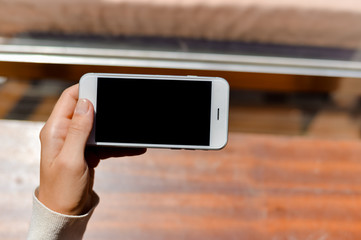 Closeup woman hand using smart phone, top view mock up background
