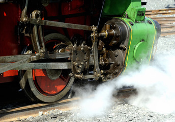 Steam locomotive wheels and rods closeup. Detail of mechanical parts, wheels and equipment of the train.