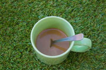 Hot coffee on green grass.