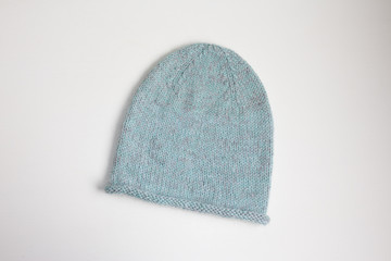 Gray-blue hat knitted by hand on a white background