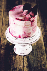 Birthday cake with berries on wooden vintage table