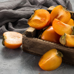 Delicious orange persimmons on wooden table .