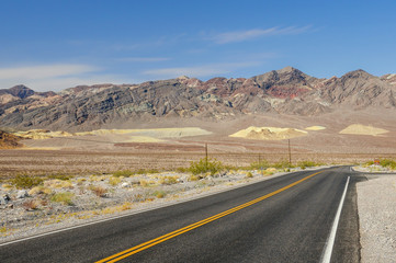 Road in Death Valley, California with mountains and artist palette canyons