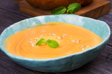 Bowl of pumpkin soup and  whole pumpkin. Butternut squash cream soup