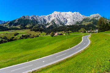Naklejka premium Beautiful alpine summer landscape. Mountains and sun, blue sky,