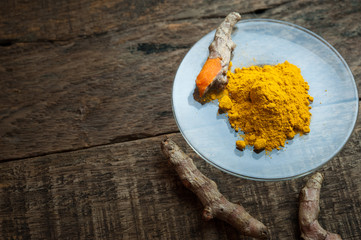 Turmeric powder on  wooden table, herbal beauty spa.