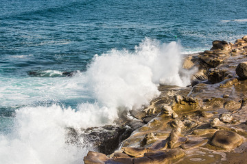 Crashing waves on La Jolla Cove rocky beach in San Diego