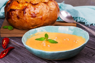 Bowl of pumpkin soup and  whole pumpkin. Butternut squash cream soup