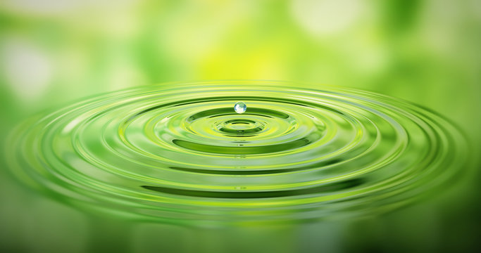 Wassertropfen auf Wasser mit grüner Spiegelung