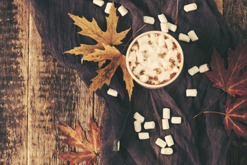 Hot cocoa with marshmallows with spices on the old wooden boards. Coffee, cocoa, cinnamon, nuts, star anise, cozy sweater Autumn Still Life
