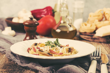 Tagliatelle with bacon cream sauce and mushrooms on wooden table