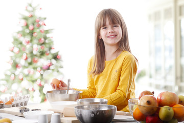 Mini chef. Portrait of cute little girl cooking and baking at home at christmas time. 