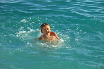 Teen boy bathing in the sea or ocean warm sunny day