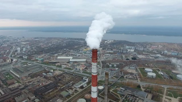 Industrial smoke against town. Pipe smoking near the cityscape. Aerial view. 4K.