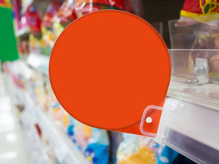 red discount sign on supermarket shelves