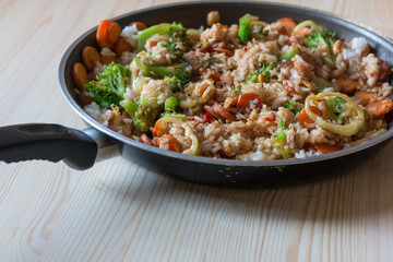 Fototapeta na wymiar Asiatische Reis- und Gemüsepfanne mit Karotten, Brokkoli, Paprika und Nüssen