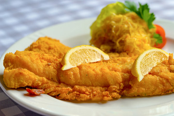 Fish dish - fried cod fish with lemon and sauerkraut.