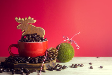coffee beans in cup with deer wood and grass ball with pine cone