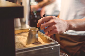 old coffee pot in hands of barista