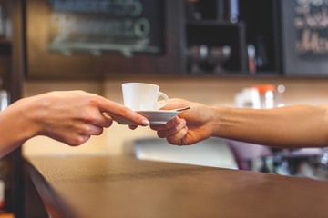 Fototapeta na wymiar waiter giving mug of latte to a client