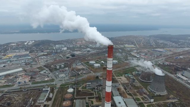 Industrial smoke against town. Pipe smoking near the cityscape. Aerial view. 4K.