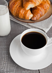 Cup of black coffee and croissant and milk