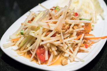 Green Papaya Salad (Som tum Thai) on wood table
