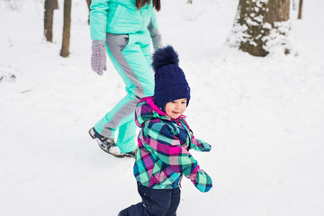 Fototapeta na wymiar Little girl and her mom having fun on a winter day