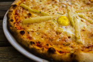 Vegetable pizza with asparagus, mozzarella and eggs.