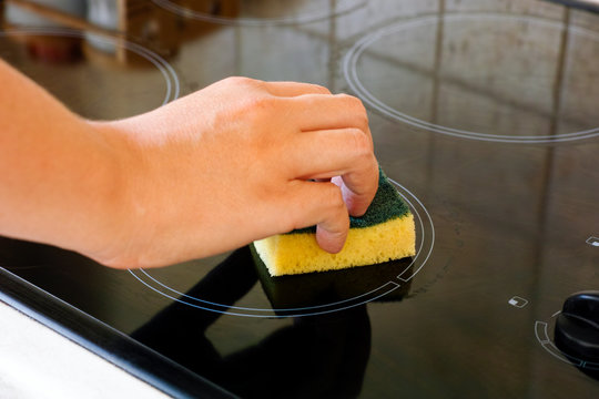 Woman Hand With Sponge Cleaning Ceramic Hob