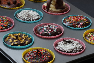 Close up of sweet homemade chocolate cupcakes with frosting on top with sugar sprinkles. Selective focus. 