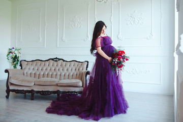 Beautiful pregnant woman in violet tender dress at luxury classic interior. Fashion pregnancy