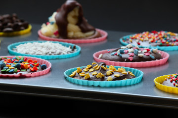 Close up of sweet homemade chocolate cupcakes with frosting on top with sugar sprinkles. Selective focus. 