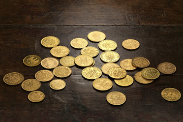 various European circulation gold coins from the 19th/20th century on rustic wooden background