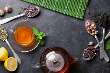 Tea cup, teapot and assortment of dry tea in spoons