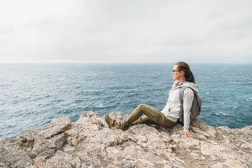 Tourist resting on rocky coast