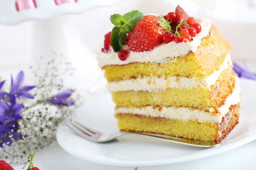 Delicious biscuit cake with berries on white wooden table