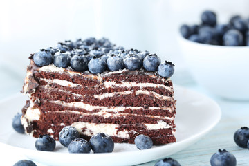 Tasty piece of cake with blueberries on wooden table