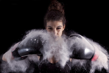 young boxer girl strikes up his gloves in the powder