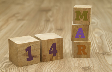 Cube shape calendar for March 14 on wooden surface.