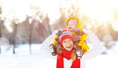 happy family mother and baby is happy snow on winter walk