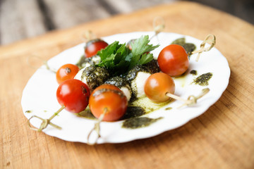 Caprese salad tomato and mozzarella with parsley and herbs on a
