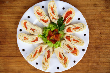 appetizer with salmon in pita bread decorated with tomato, salad