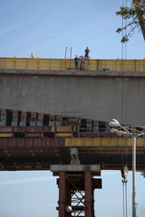 Two workers in workwear high on a bridge processing construction works