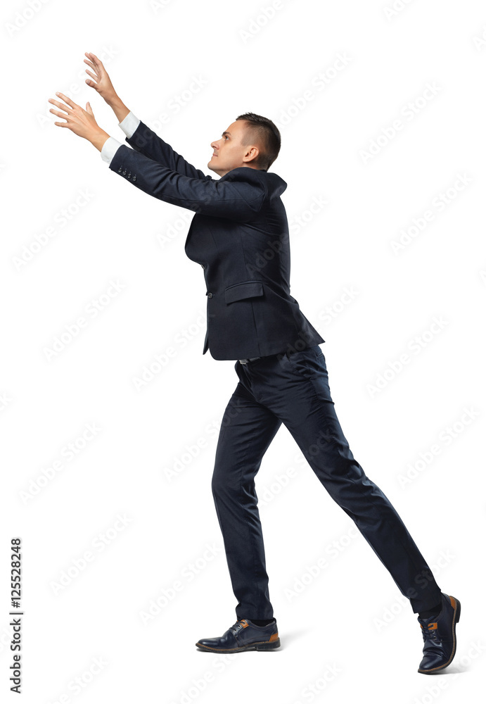 Wall mural businessman in profile with his leg set back and hands up in catching pose, isolated on white backgr