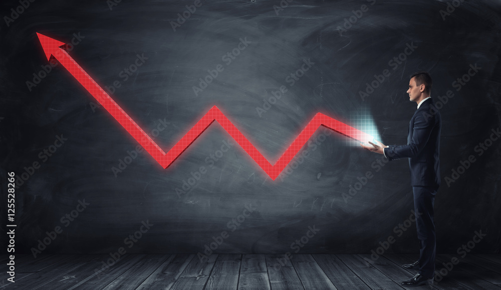 Poster huge red line graph with an upturned arrow growing from a businessman hands